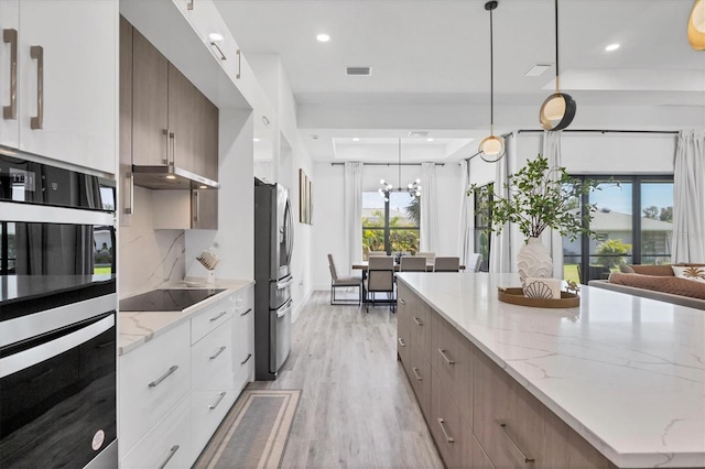 10270 Castanet Ave, Englewood, FL 34224 - kitchen with modern cabinets, black appliances, light wood-style floors, a chandelier, and under cabinet range hood