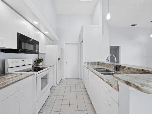 3223 Jamaica St, Sarasota, FL 34231 - kitchen featuring white appliances, white cabinets, light stone counters, and light tile patterned flooring