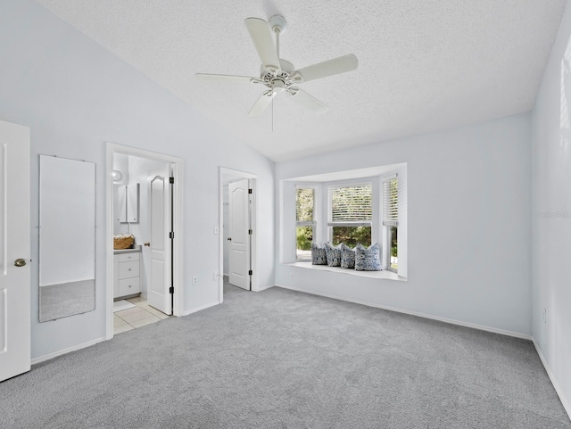 3223 Jamaica St, Sarasota, FL 34231 - unfurnished bedroom featuring carpet, a textured ceiling, lofted ceiling, ensuite bathroom, and ceiling fan