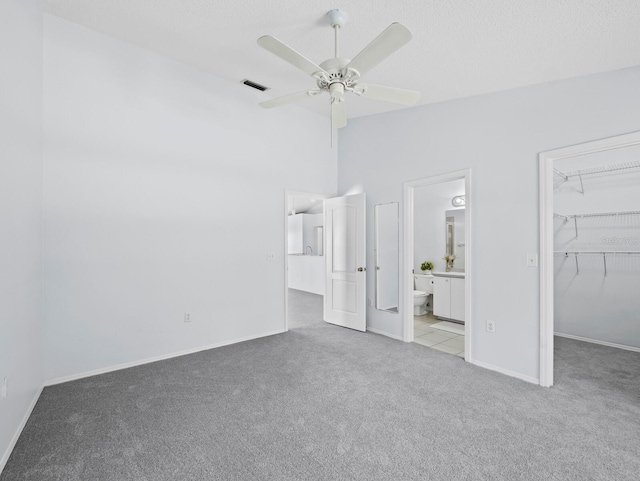 3223 Jamaica St, Sarasota, FL 34231 - unfurnished bedroom featuring carpet, a walk in closet, ensuite bathroom, and ceiling fan