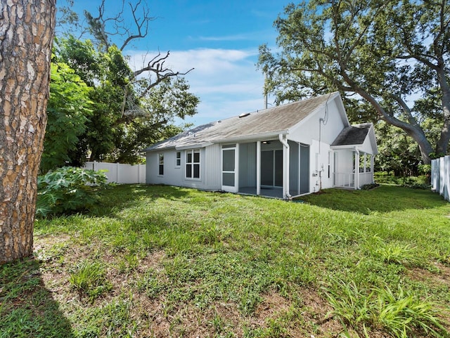 3223 Jamaica St, Sarasota, FL 34231 - back of property featuring a fenced backyard, a sunroom, and roof with shingles