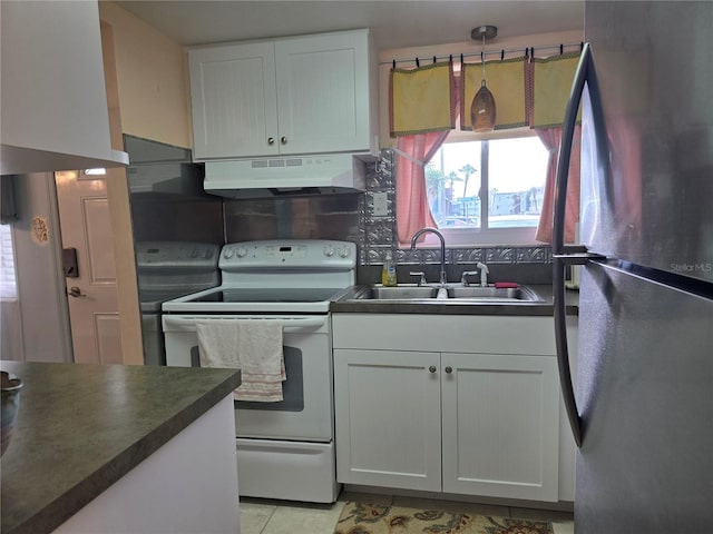 5850 Welcome Rd Unit J6, Bradenton, FL 34207 - kitchen featuring freestanding refrigerator, under cabinet range hood, white electric stove, dark countertops, and white cabinets