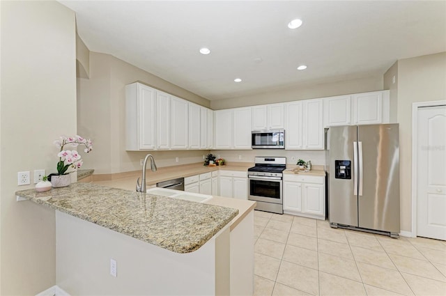 7039 Woodmore Ter, Lakewood Ranch, FL 34202 - kitchen featuring stainless steel appliances, a peninsula, light tile patterned flooring, white cabinetry, and recessed lighting