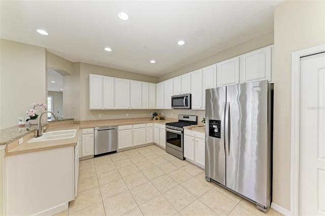 7039 Woodmore Ter, Lakewood Ranch, FL 34202 - kitchen featuring appliances with stainless steel finishes, light countertops, light tile patterned flooring, recessed lighting, and arched walkways