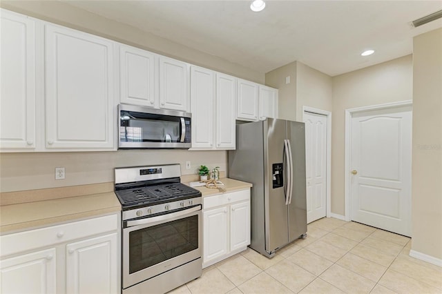 7039 Woodmore Ter, Lakewood Ranch, FL 34202 - kitchen featuring stainless steel appliances, light tile patterned flooring, recessed lighting, white cabinetry, and light countertops