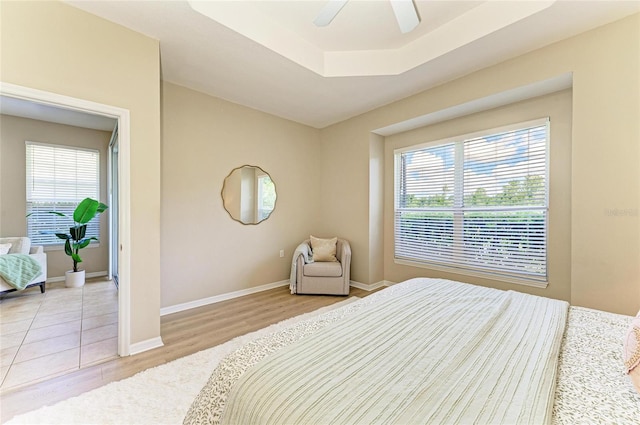 7039 Woodmore Ter, Lakewood Ranch, FL 34202 - bedroom with wood finished floors, a ceiling fan, and a raised ceiling