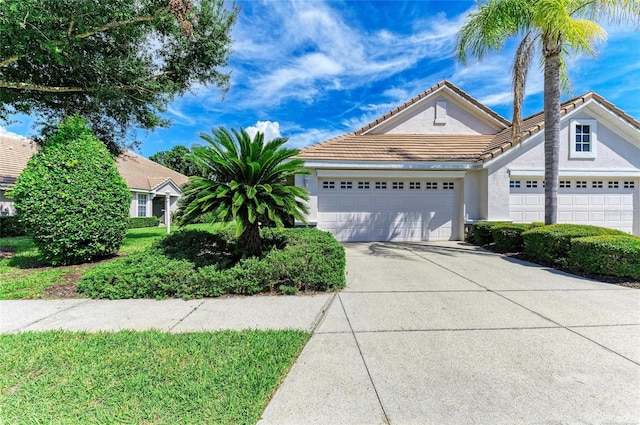 7039 Woodmore Ter, Lakewood Ranch, FL 34202 - view of front facade featuring concrete driveway, a garage, a tiled roof, and stucco siding