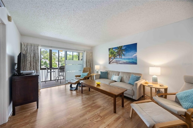 2220 Stickney Point Rd Unit 528, Sarasota, FL 34231 - living room featuring a textured ceiling and wood finished floors