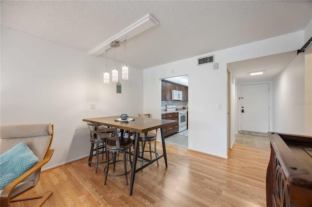2220 Stickney Point Rd Unit 528, Sarasota, FL 34231 - dining room with light wood-style floors and a textured ceiling
