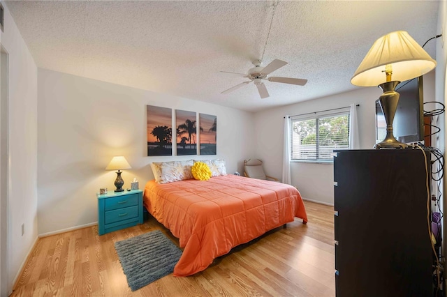 2220 Stickney Point Rd Unit 528, Sarasota, FL 34231 - bedroom with a textured ceiling, light wood-style flooring, and ceiling fan