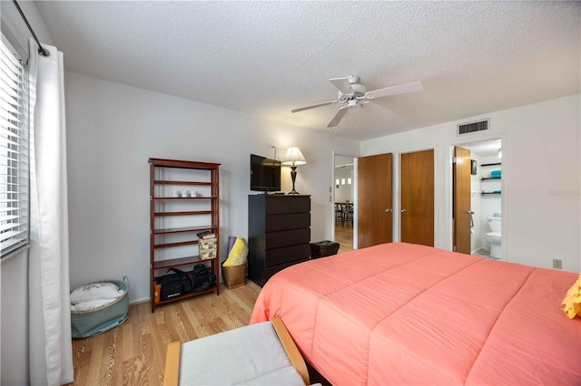 2220 Stickney Point Rd Unit 528, Sarasota, FL 34231 - bedroom with light wood-type flooring, a textured ceiling, ceiling fan, and ensuite bathroom