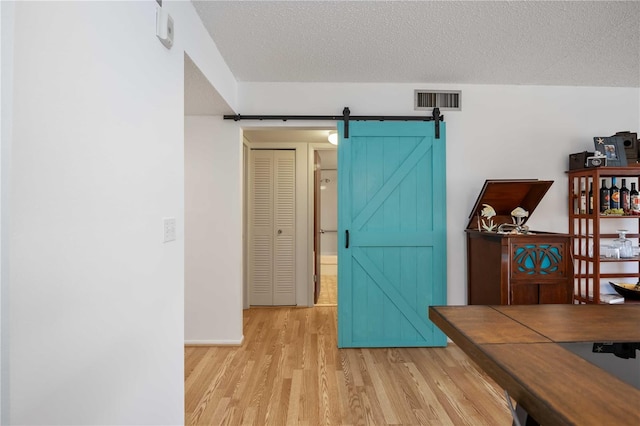 2220 Stickney Point Rd Unit 528, Sarasota, FL 34231 - home office featuring a barn door, light wood-style floors, and a textured ceiling