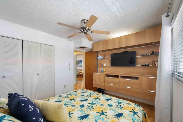 2220 Stickney Point Rd Unit 528, Sarasota, FL 34231 - bedroom with light wood-style flooring, a closet, a textured ceiling, and ceiling fan