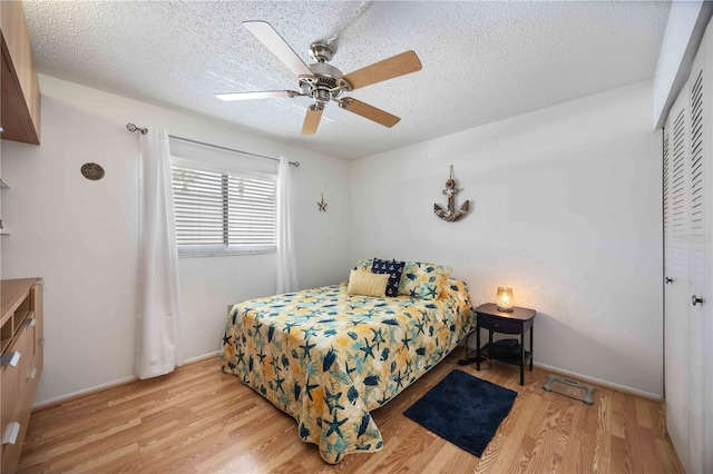 2220 Stickney Point Rd Unit 528, Sarasota, FL 34231 - bedroom featuring wood finished floors, a closet, a textured ceiling, and a ceiling fan