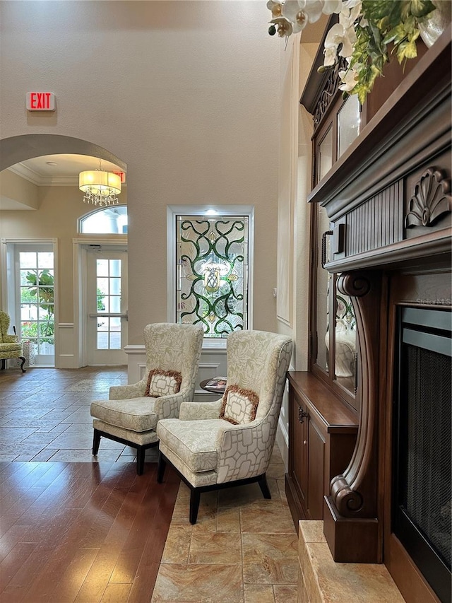 6713 Stone River Rd Unit 101, Bradenton, FL 34203 - sitting room featuring crown molding, arched walkways, a high ceiling, light wood-style floors, and a chandelier
