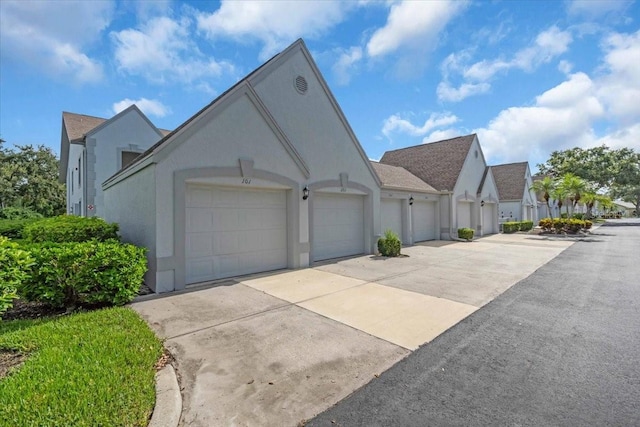 6713 Stone River Rd Unit 101, Bradenton, FL 34203 - view of side of property with stucco siding, a garage, and concrete driveway