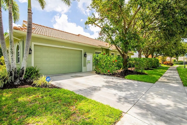 471 Park Trace Blvd, Osprey, FL 34229 - view of front facade with a tiled roof, concrete driveway, an attached garage, and stucco siding