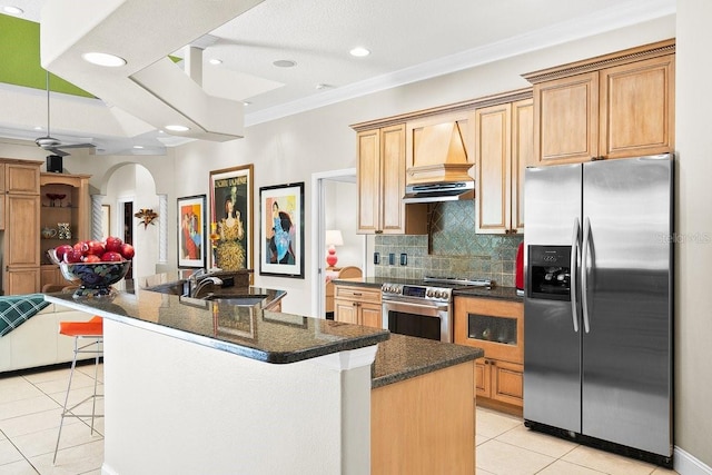 471 Park Trace Blvd, Osprey, FL 34229 - kitchen with appliances with stainless steel finishes, light tile patterned floors, crown molding, arched walkways, and backsplash