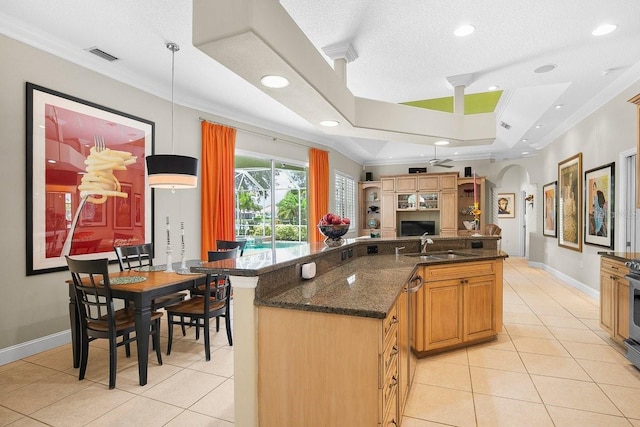 471 Park Trace Blvd, Osprey, FL 34229 - kitchen with light tile patterned floors, crown molding, open floor plan, arched walkways, and dark stone counters