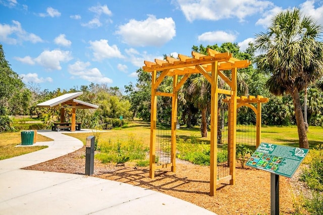 471 Park Trace Blvd, Osprey, FL 34229 - view of property's community featuring a yard, a pergola, and view of wooded area