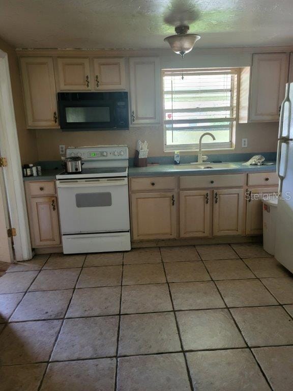 2532 Grand Cayman St, Sarasota, FL 34231 - kitchen featuring white appliances, light tile patterned floors, cream cabinetry, and light countertops