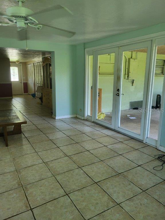 2532 Grand Cayman St, Sarasota, FL 34231 - unfurnished living room featuring light tile patterned floors, ceiling fan, and french doors