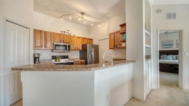 8397 38th Street Cir E Unit 306, Sarasota, FL 34243 - kitchen with stainless steel appliances, open shelves, tasteful backsplash, brown cabinets, and ceiling fan