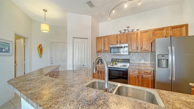 8397 38th Street Cir E Unit 306, Sarasota, FL 34243 - kitchen featuring stainless steel appliances, brown cabinetry, decorative backsplash, and decorative light fixtures