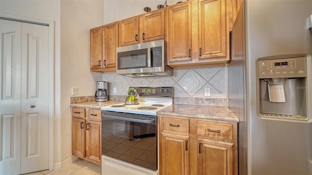 8397 38th Street Cir E Unit 306, Sarasota, FL 34243 - kitchen featuring appliances with stainless steel finishes, tasteful backsplash, and light tile patterned floors