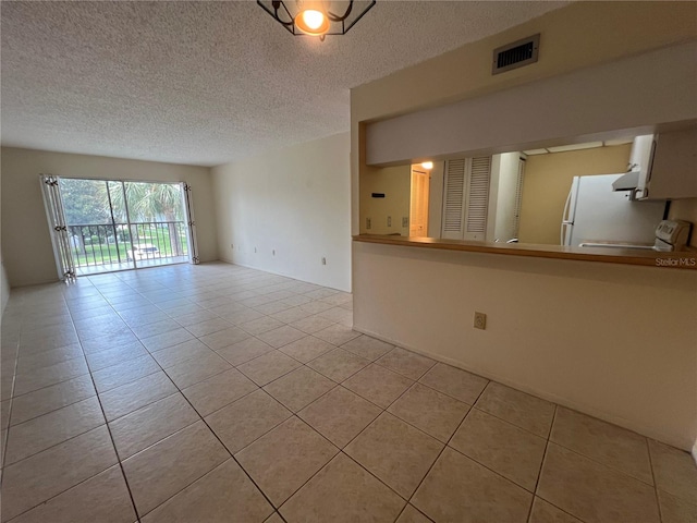 3231 Beneva Rd Unit 202, Sarasota, FL 34232 - unfurnished living room featuring light tile patterned flooring and a textured ceiling