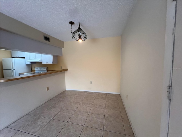 3231 Beneva Rd Unit 202, Sarasota, FL 34232 - kitchen featuring white appliances, under cabinet range hood, light tile patterned floors, a textured ceiling, and white cabinets