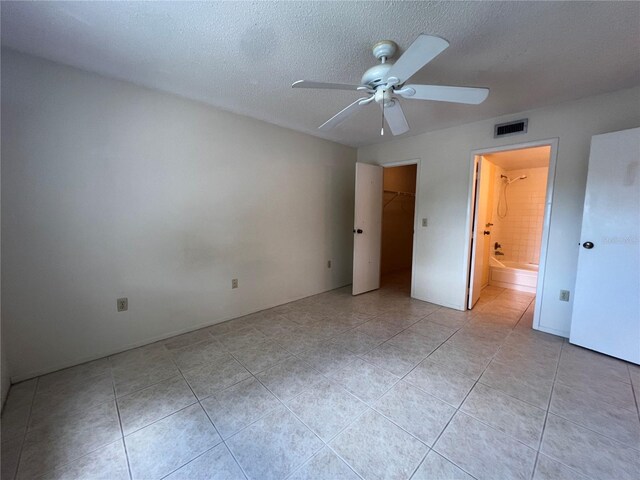 3231 Beneva Rd Unit 202, Sarasota, FL 34232 - unfurnished bedroom with light tile patterned flooring, a textured ceiling, connected bathroom, and a ceiling fan