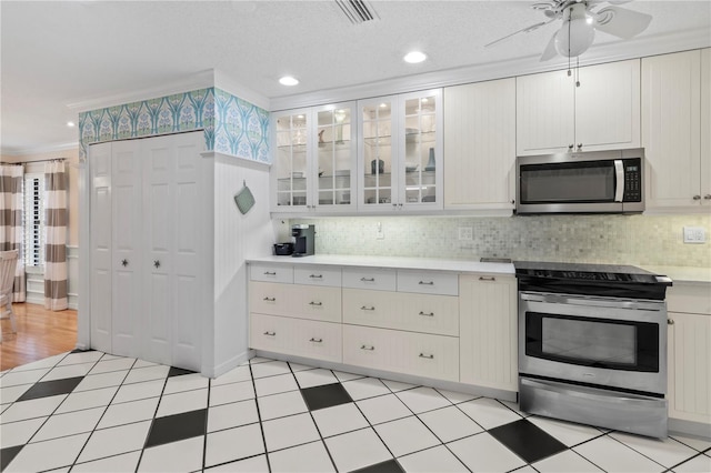 6818 Arbor Oaks Cir, Bradenton, FL 34209 - kitchen featuring stainless steel appliances, light countertops, a ceiling fan, crown molding, and tasteful backsplash