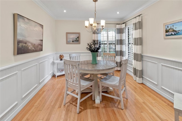 6818 Arbor Oaks Cir, Bradenton, FL 34209 - dining area with a wainscoted wall, ornamental molding, a chandelier, light wood-type flooring, and a decorative wall