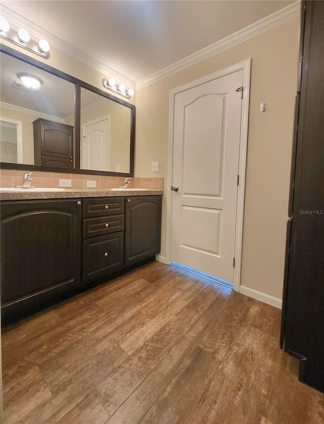 1106 49th Avenue Dr W, Bradenton, FL 34207 - bathroom featuring double vanity, crown molding, and wood finished floors