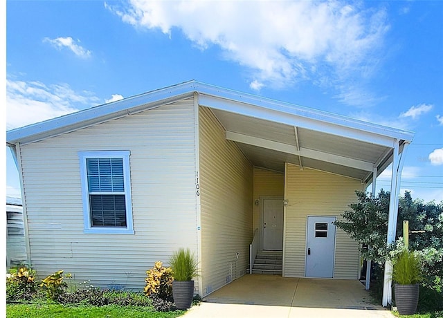 1106 49th Avenue Dr W, Bradenton, FL 34207 - back of house with concrete driveway, an attached carport, and entry steps
