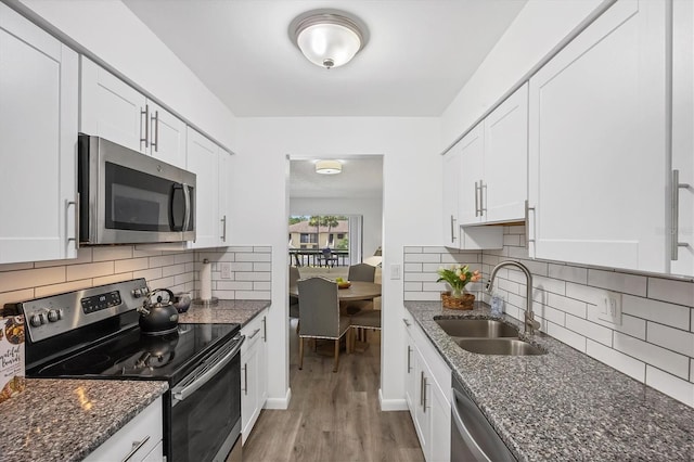 4658 Longwater Chase Unit 104, Sarasota, FL 34235 - kitchen featuring appliances with stainless steel finishes, light wood finished floors, and white cabinetry