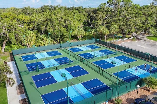 4658 Longwater Chase Unit 104, Sarasota, FL 34235 - view of tennis court featuring a forest view