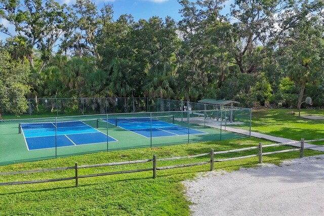 4658 Longwater Chase Unit 104, Sarasota, FL 34235 - view of tennis court with view of wooded area