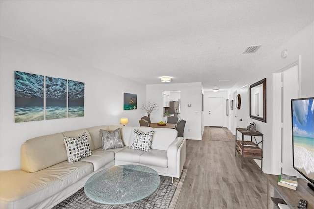 4658 Longwater Chase Unit 104, Sarasota, FL 34235 - living area featuring light wood-style floors and a textured ceiling