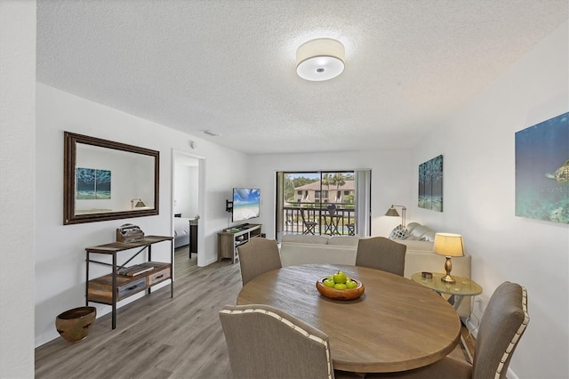 4658 Longwater Chase Unit 104, Sarasota, FL 34235 - dining room with a textured ceiling and light wood finished floors