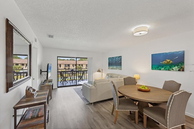 4658 Longwater Chase Unit 104, Sarasota, FL 34235 - dining room featuring wood finished floors and a textured ceiling