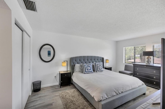 4658 Longwater Chase Unit 104, Sarasota, FL 34235 - bedroom with a textured ceiling, wood finished floors, and a closet