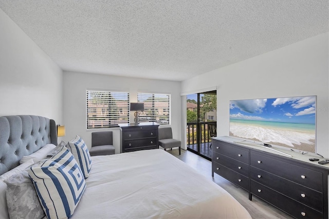 4658 Longwater Chase Unit 104, Sarasota, FL 34235 - bedroom with access to outside, a textured ceiling, and wood finished floors