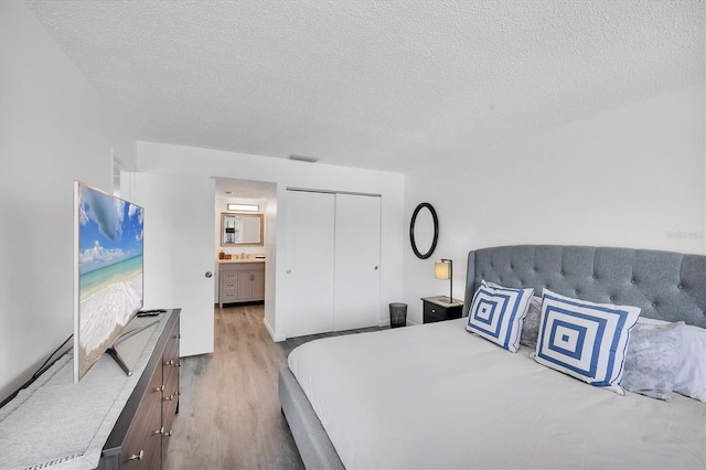 4658 Longwater Chase Unit 104, Sarasota, FL 34235 - bedroom with wood finished floors, a textured ceiling, and a closet