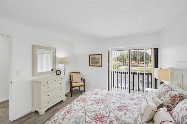 4658 Longwater Chase Unit 104, Sarasota, FL 34235 - bedroom featuring access to outside, light wood-style floors, a textured ceiling, and a water view