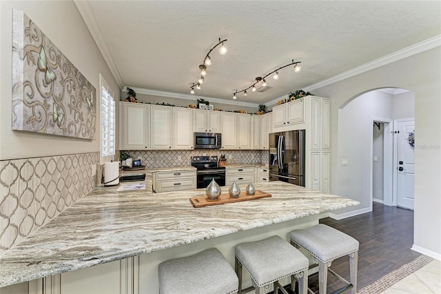 3911 91st Ave E, Parrish, FL 34219 - kitchen featuring black fridge, stainless steel microwave, electric range, arched walkways, and a peninsula