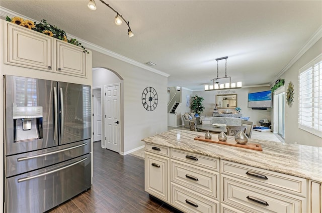 3911 91st Ave E, Parrish, FL 34219 - kitchen featuring stainless steel fridge, cream cabinetry, arched walkways, open floor plan, and ornamental molding