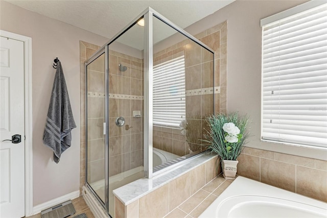 3911 91st Ave E, Parrish, FL 34219 - bathroom featuring a bath, a stall shower, and plenty of natural light