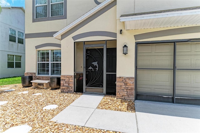 3911 91st Ave E, Parrish, FL 34219 - entrance to property featuring a garage, stone siding, and stucco siding
